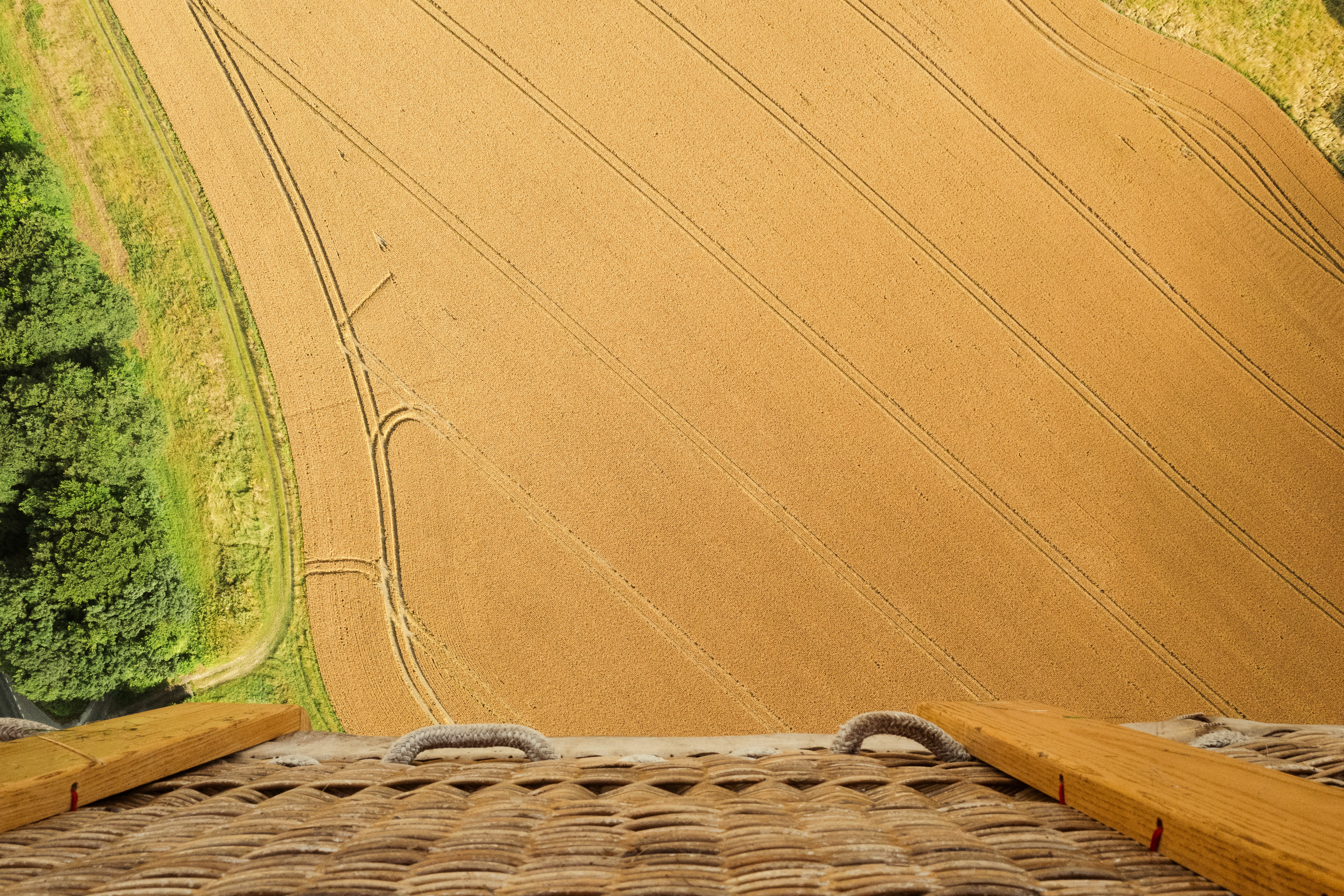 एक मंडी में ढेर सारे गेहूं के बोरों के पास बैठे परेशान किसान और बीच में एक खाली ढेर जिसे भरा जाना है।