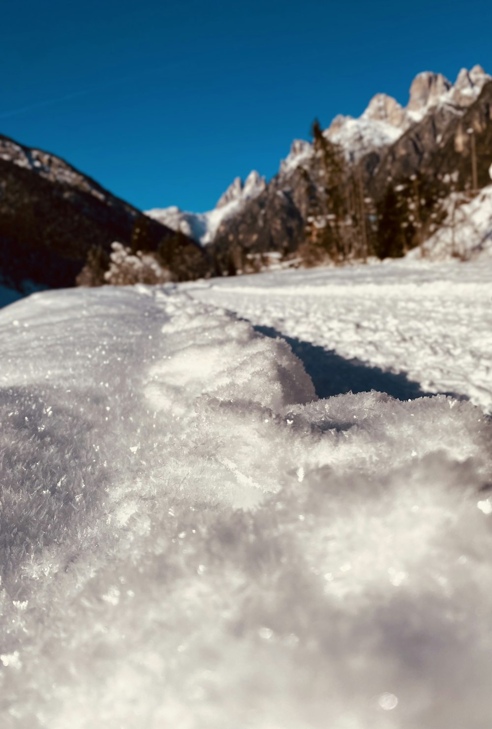 a snow covered ground with mountains in the background