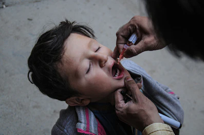 a little boy getting his teeth brushed by an adult