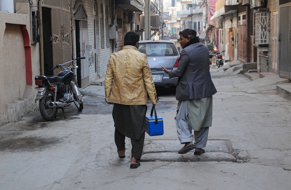 Foto Um homem e uma mulher andando por uma rua – Imagem de Paquistão grátis  no Unsplash