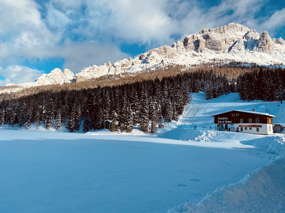 a snow covered mountain with a house in the foreground