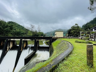 a dam in the middle of a lush green field