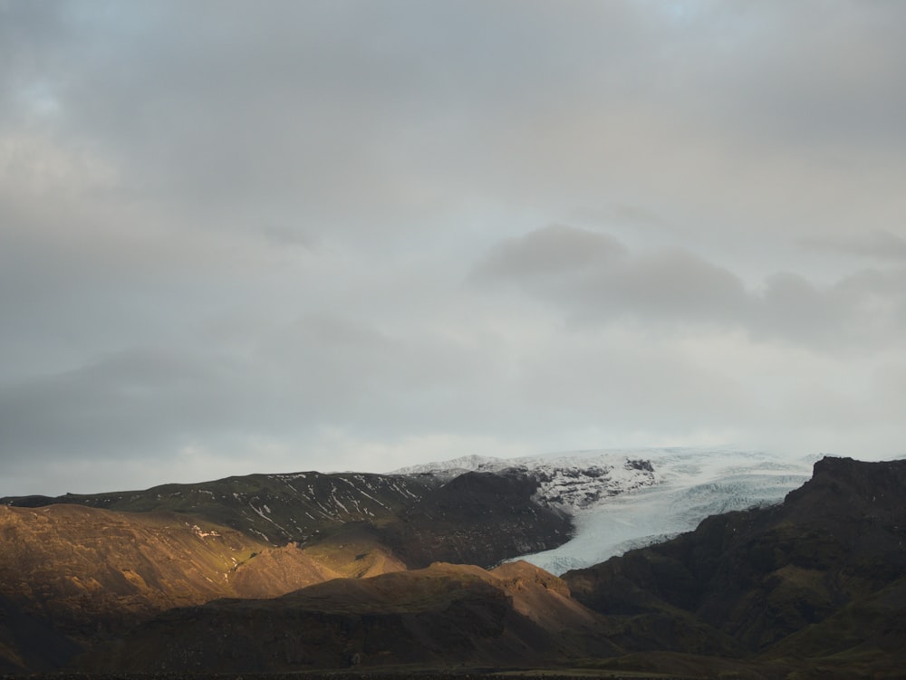 una vista di una catena montuosa con un ghiacciaio in lontananza