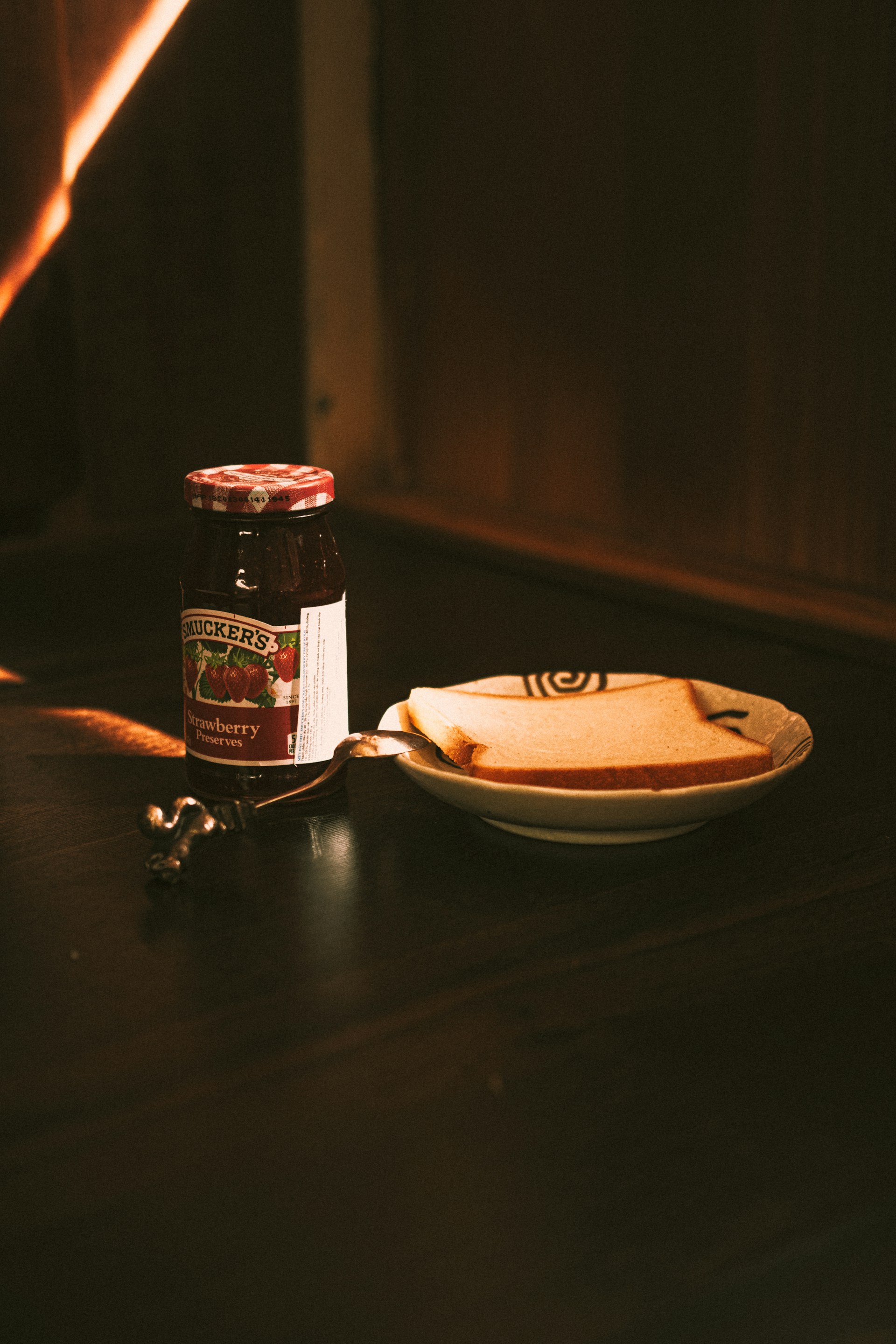 a plate of food and a jar of jam on a table