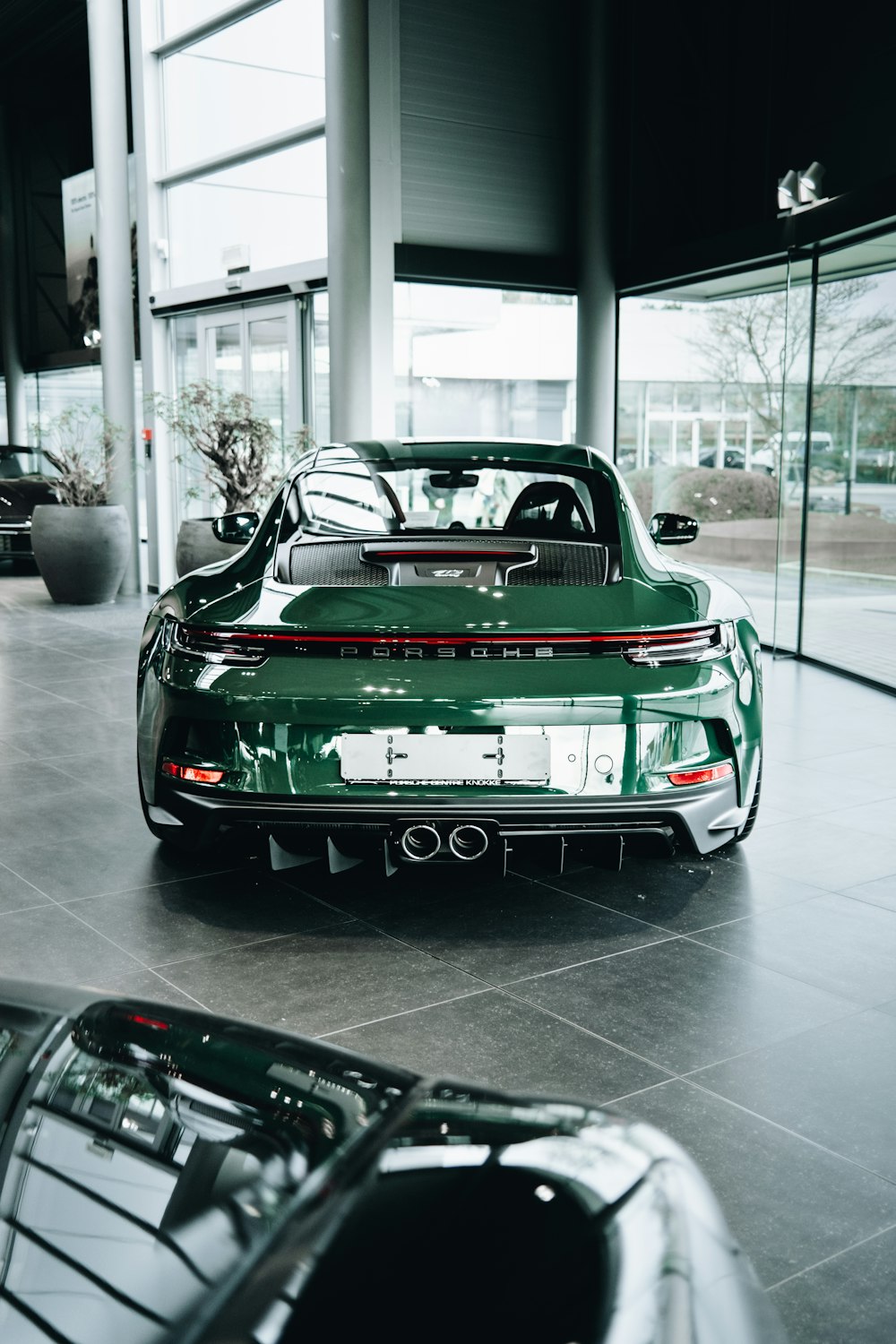 a green sports car parked in a showroom