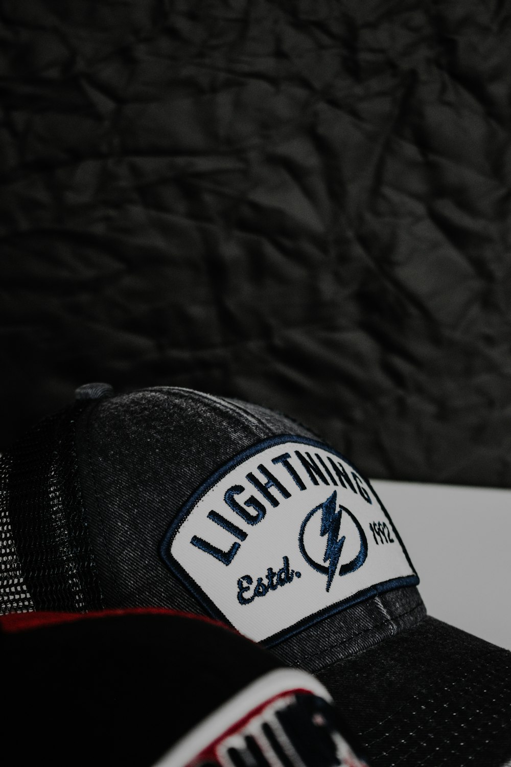 a black hat with a lightning patch on it