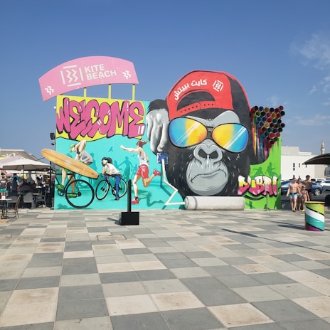 A vibrant street mural depicting the history and culture of Guinea, filled with bright colors and symbolic imagery.