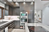 a modern kitchen with stainless steel appliances and marble counter tops