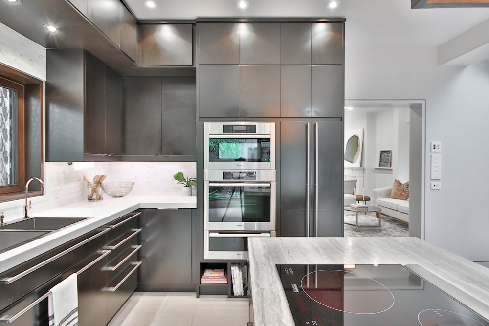 a modern kitchen with stainless steel appliances and marble counter tops