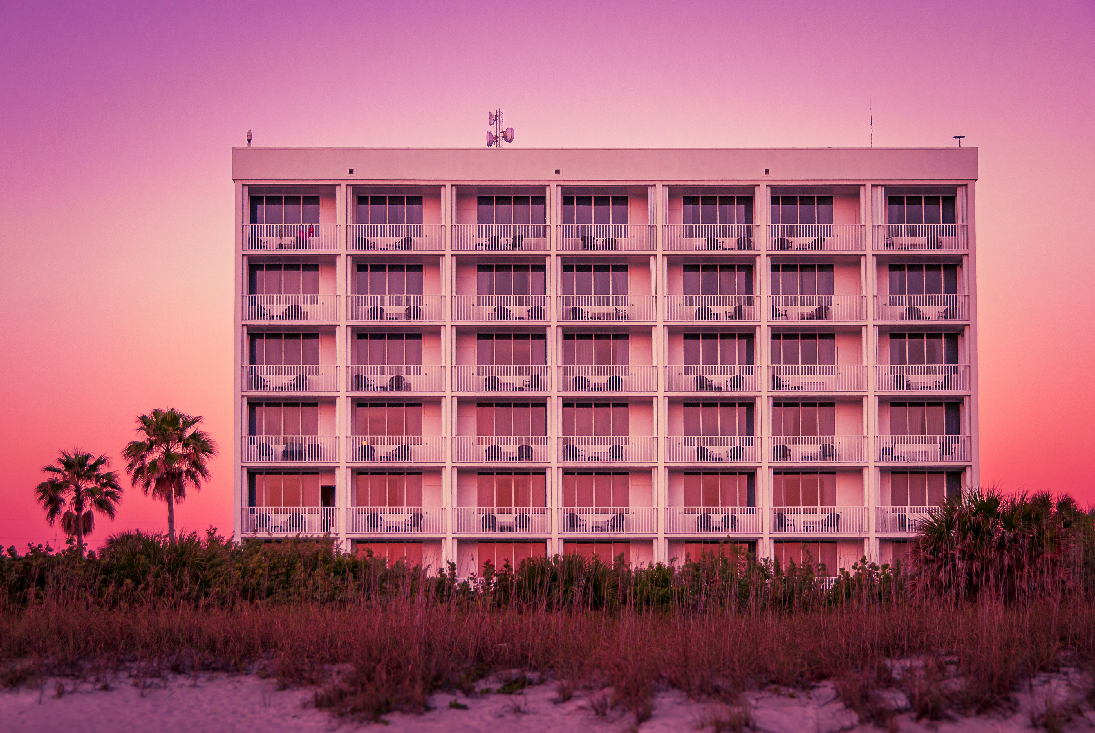 a tall white building sitting on top of a sandy beach