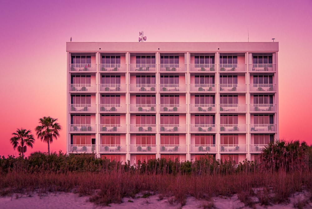 a tall white building sitting on top of a sandy beach