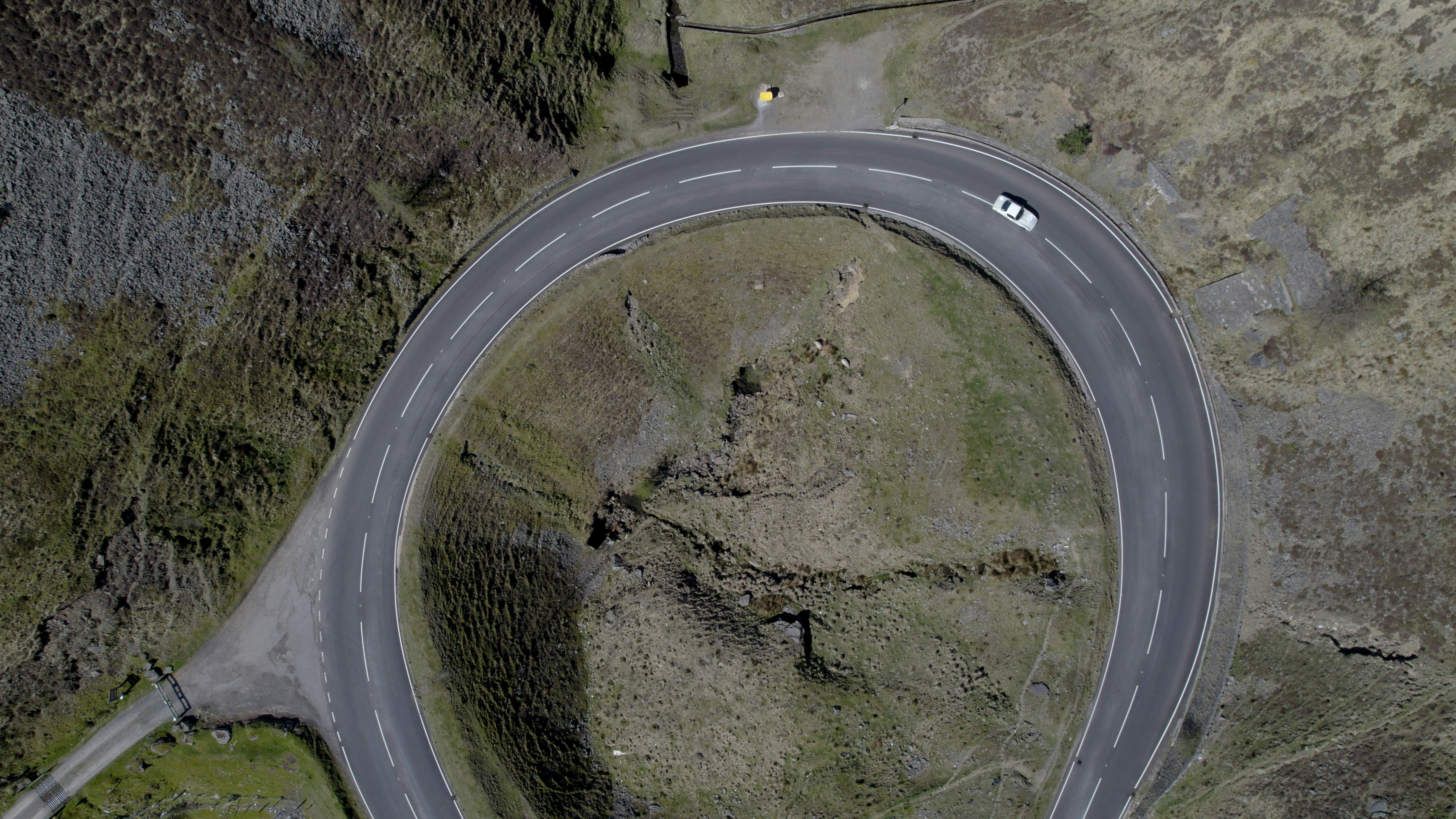 an aerial view of a curved road in the mountains