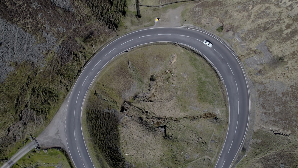 an aerial view of a curved road in the mountains