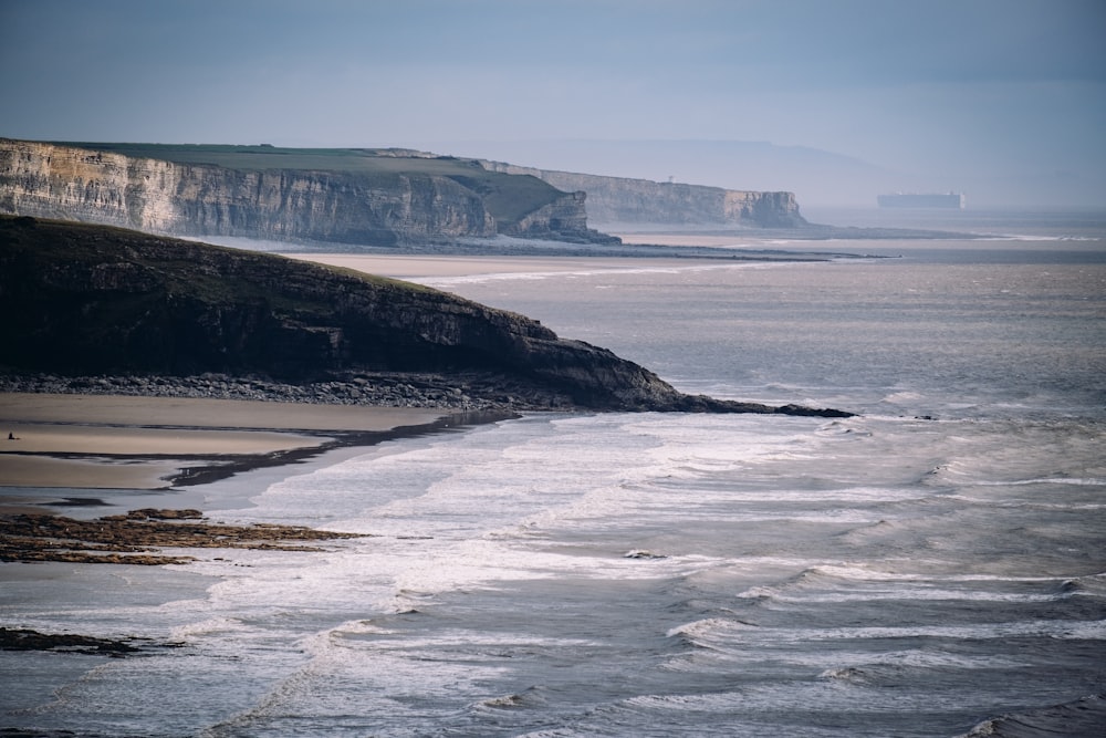 a body of water with a cliff in the background