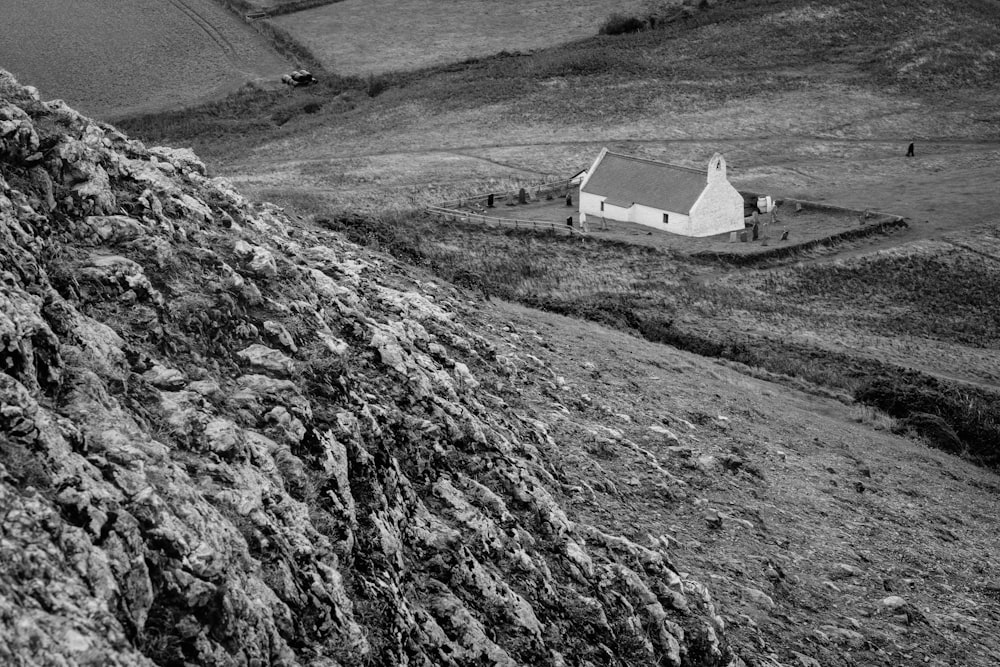 Una foto en blanco y negro de una casa en una colina