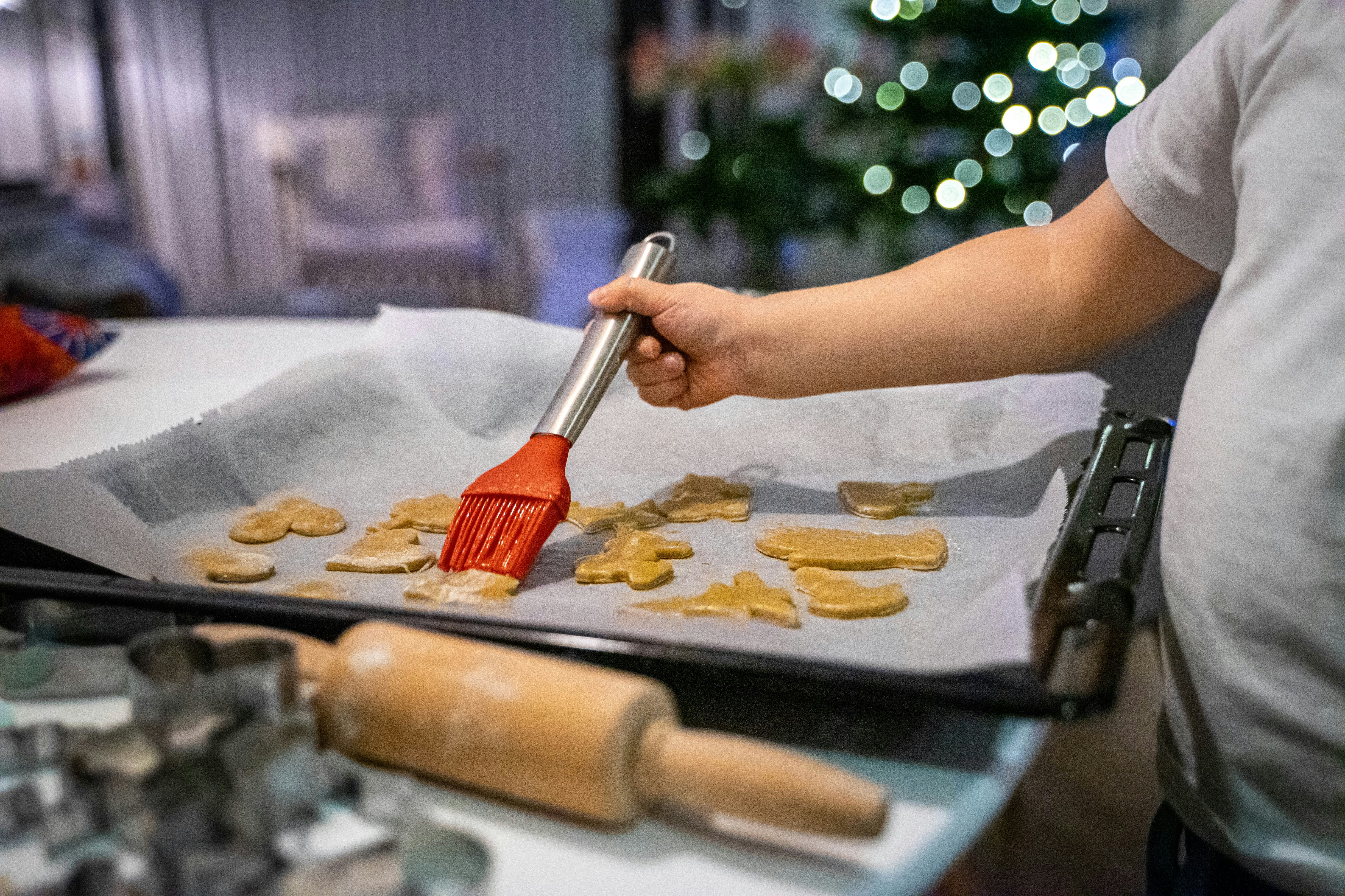 a person with a brush is making cookies