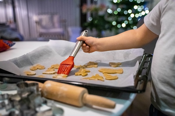 a person with a brush is making cookies