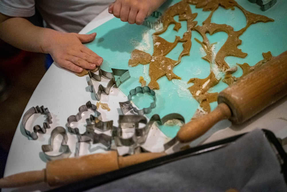 a child is making cookie cutters on a table