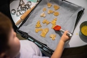 a child is making cookies on a tray
