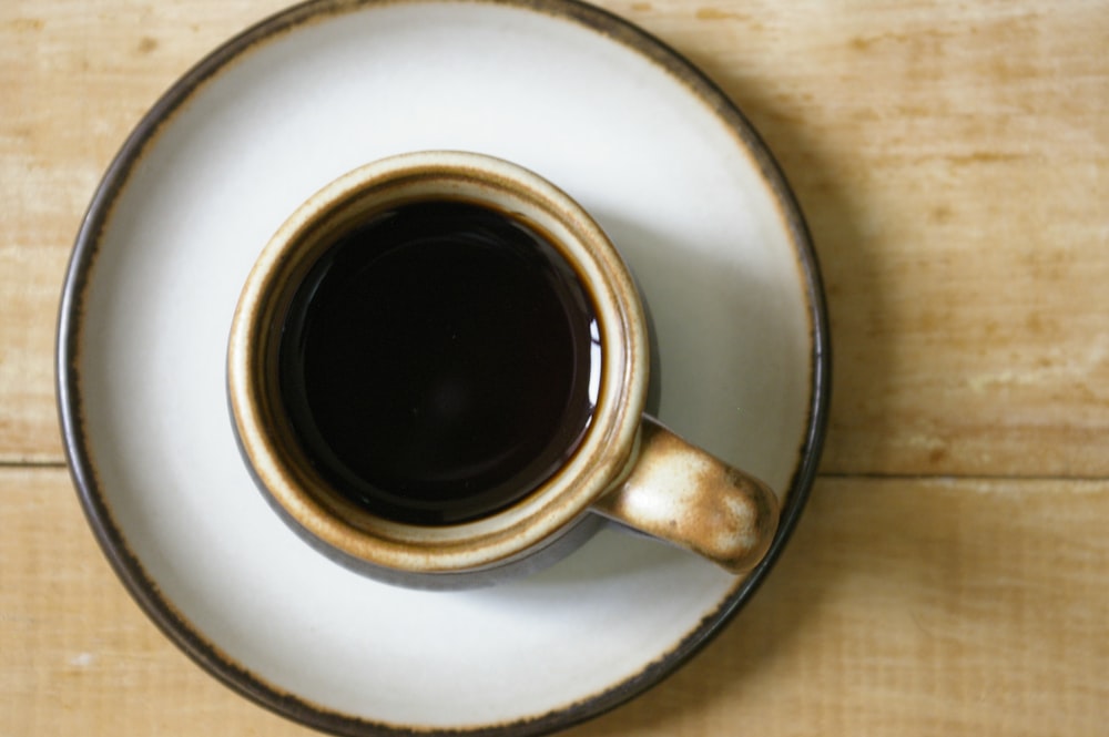 a cup of coffee sitting on top of a white saucer