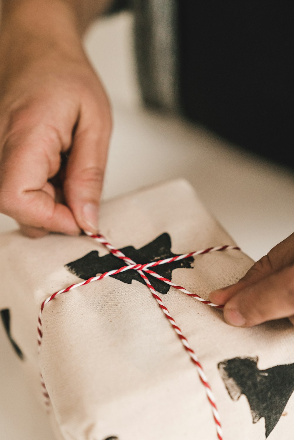 a person tying a string to a wrapped present