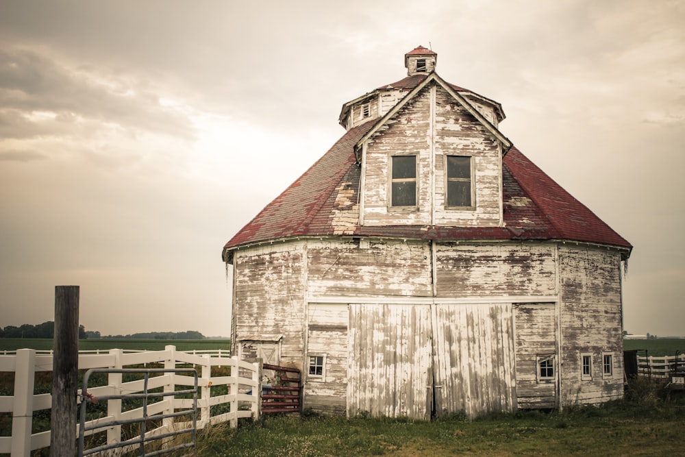 an old white barn with a red roof