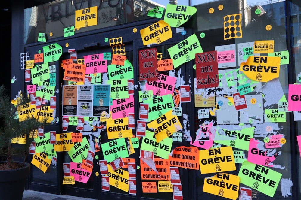 a bunch of colorful sticky notes on a building