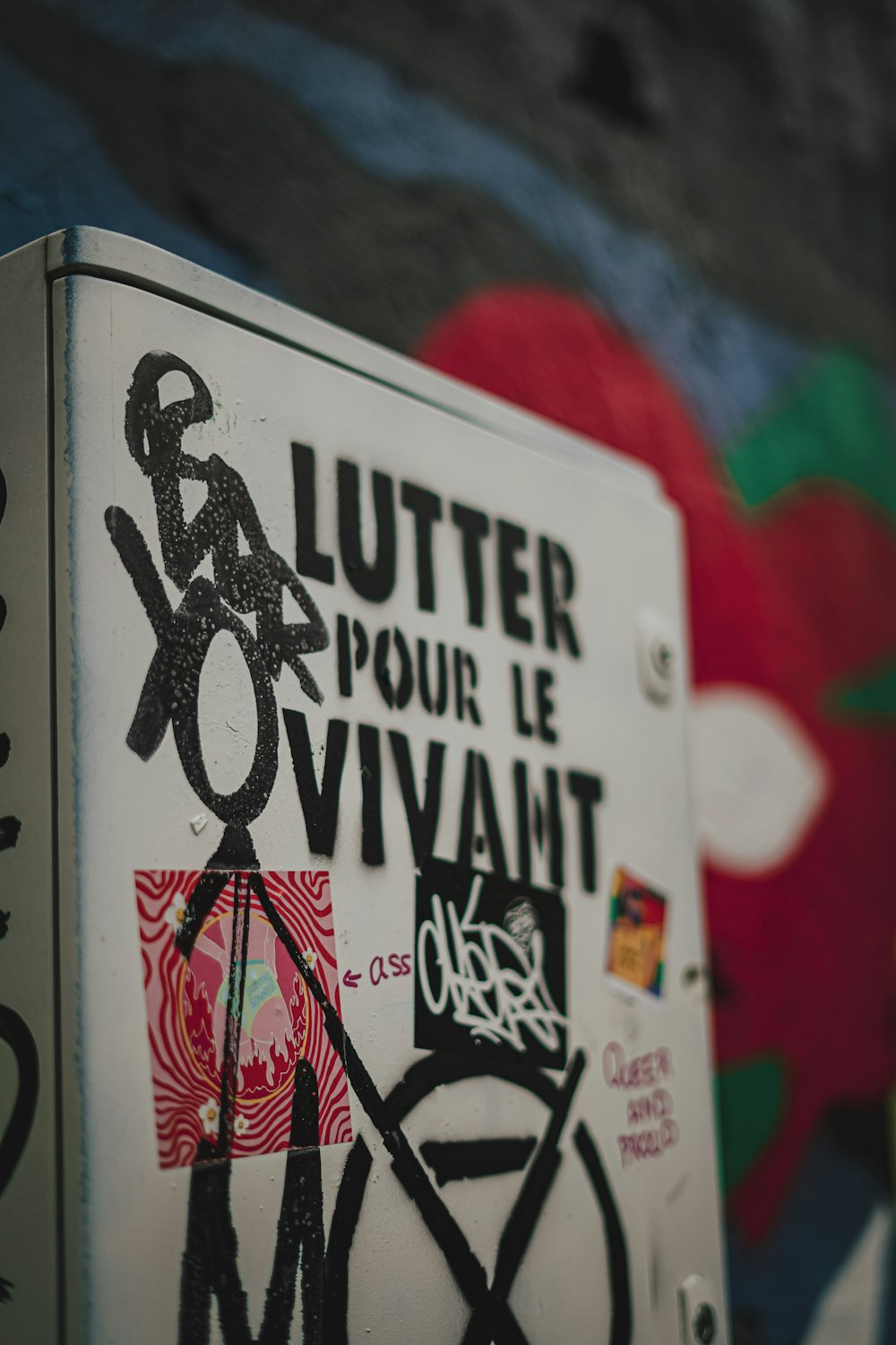 a white refrigerator covered in graffiti next to a wall