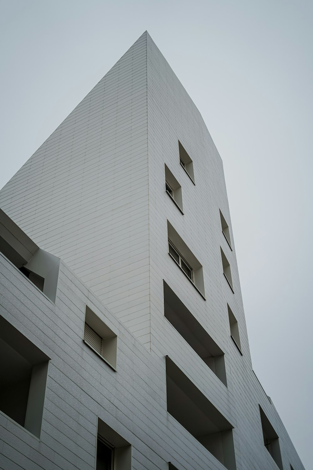 a tall white building with windows on the side of it