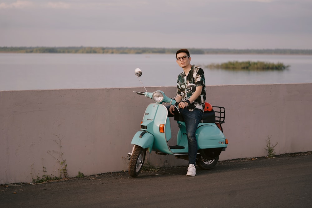 a man sitting on a scooter next to a wall