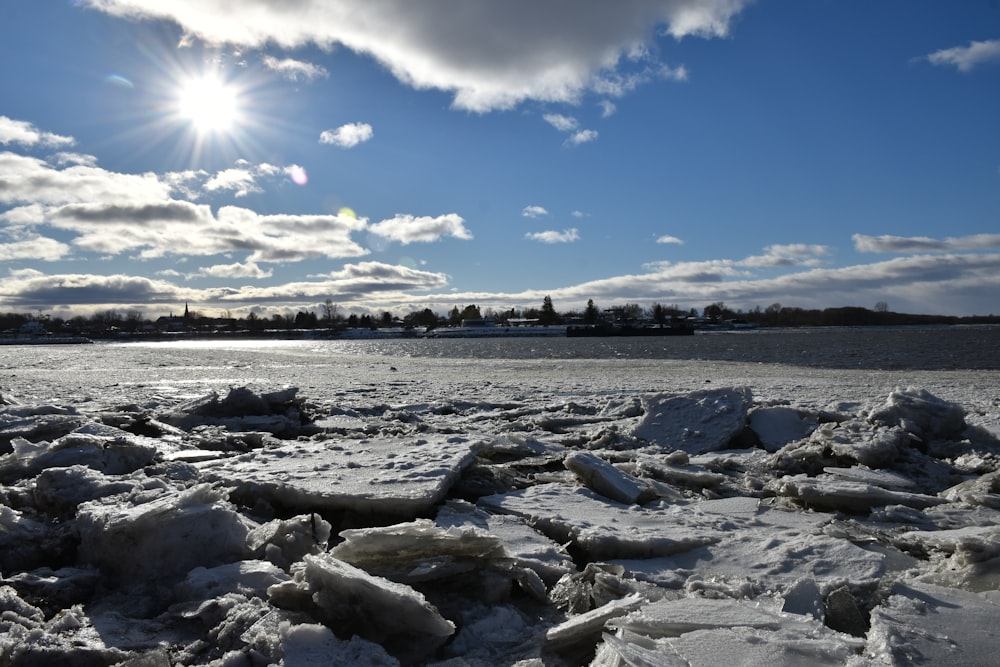 the sun is shining over a frozen lake