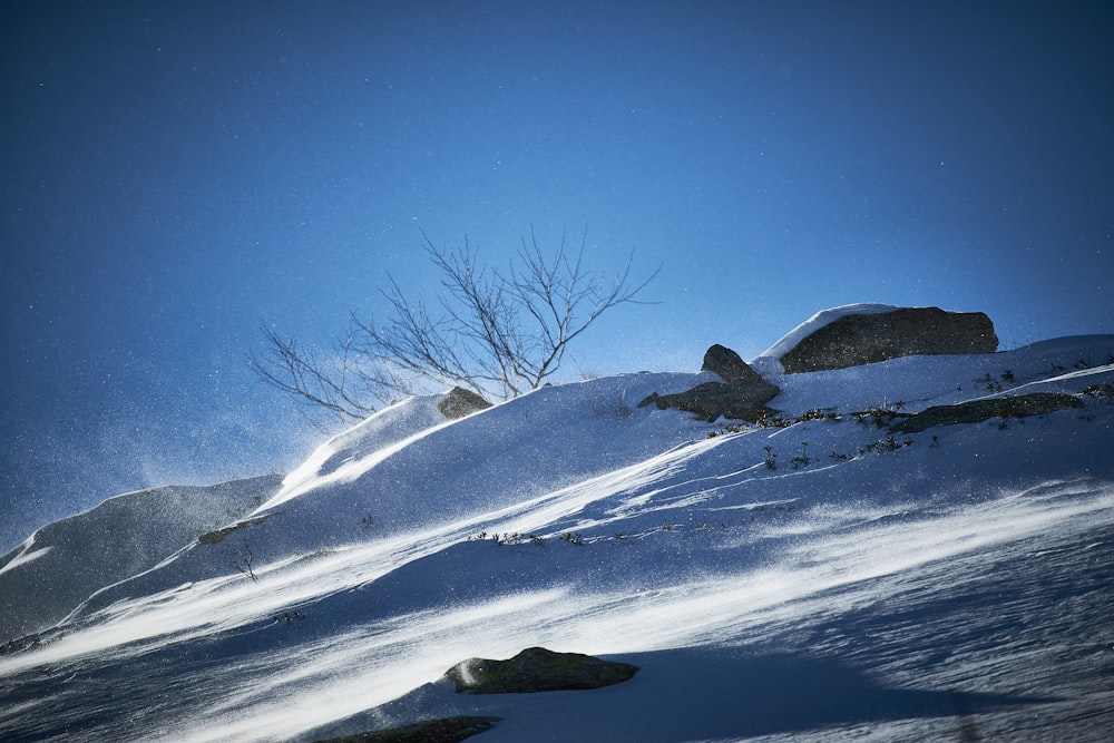 a person riding a snowboard down a snow covered slope