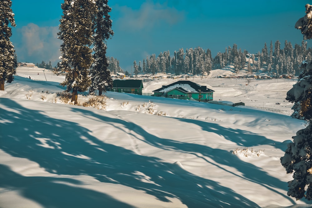 ein schneebedeckter Hügel mit einem Haus in der Ferne