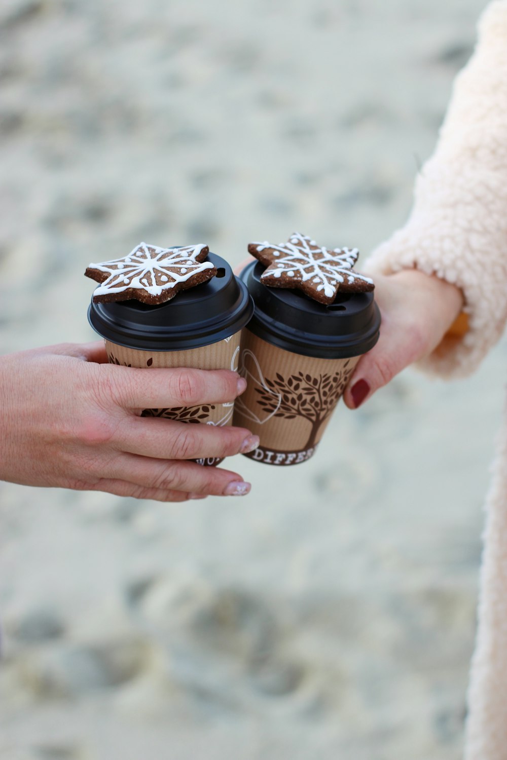 a person holding a cup of coffee with a snowflake on it