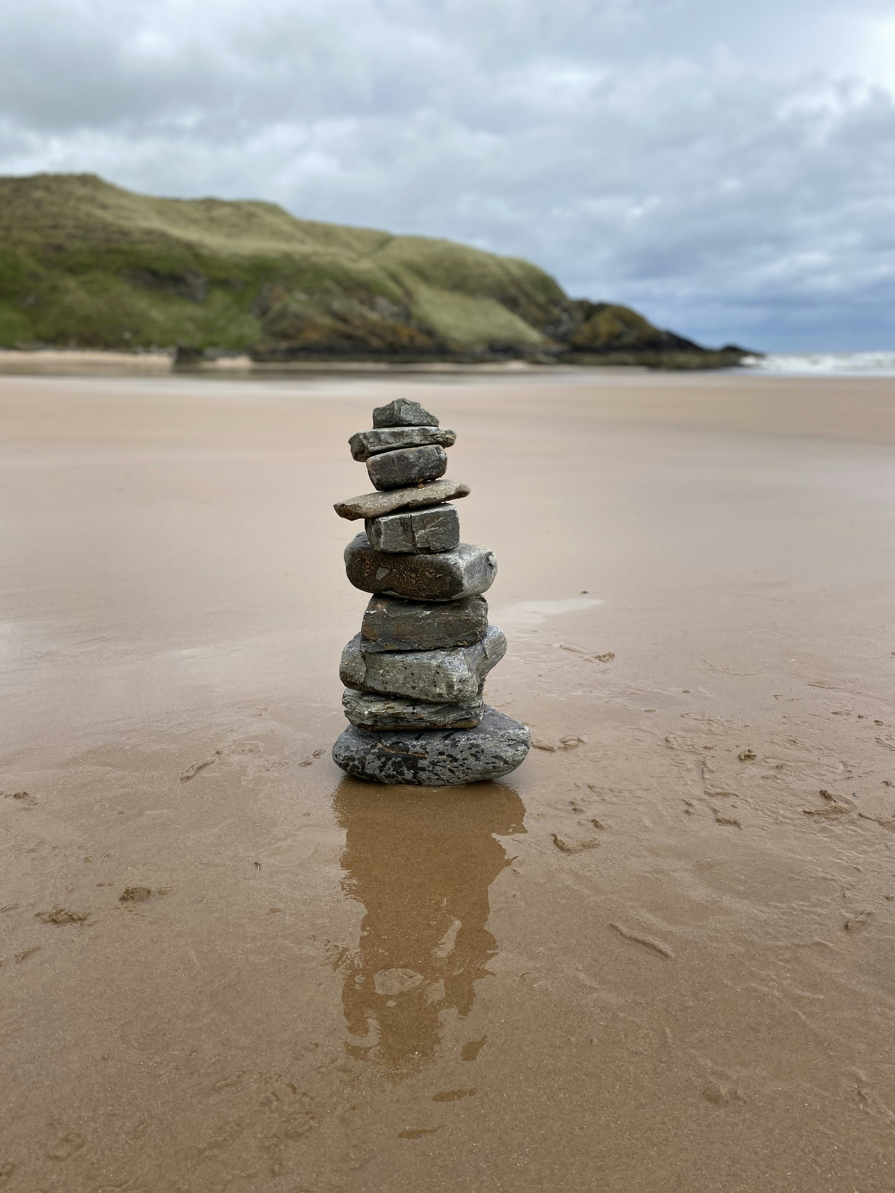 A stack of rocks sitting on top of a sandy beach photo – Free ...