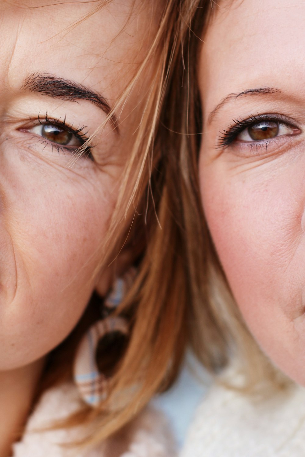 a close up of two women with brown eyes
