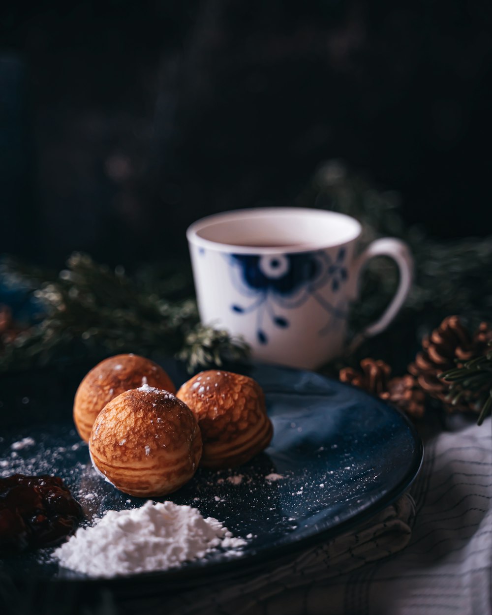 a blue plate topped with pastries next to a cup of coffee