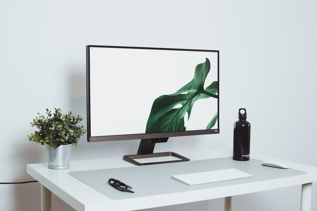 a computer monitor sitting on top of a white desk,