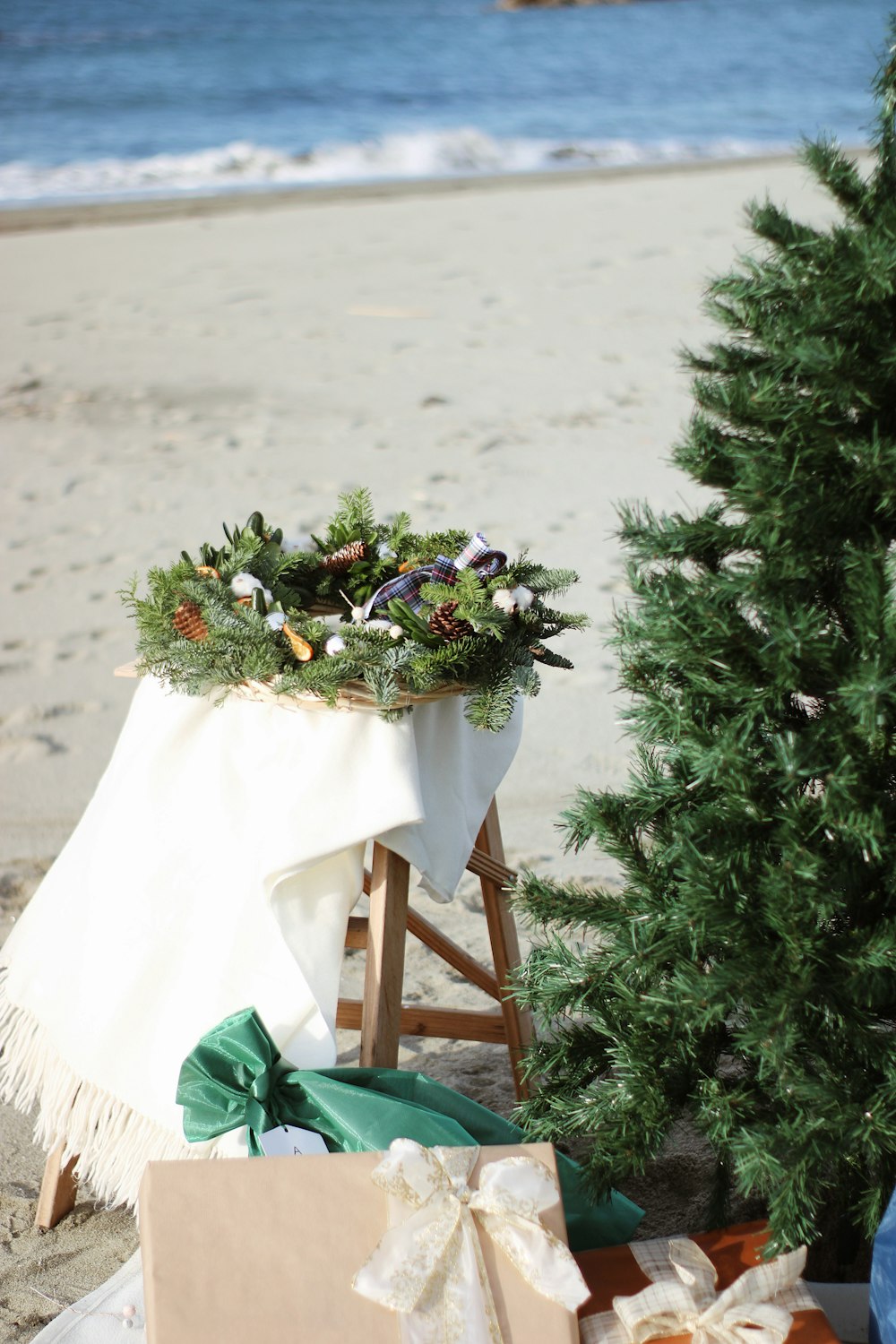 Un sapin de Noël sur la plage avec des cadeaux en dessous