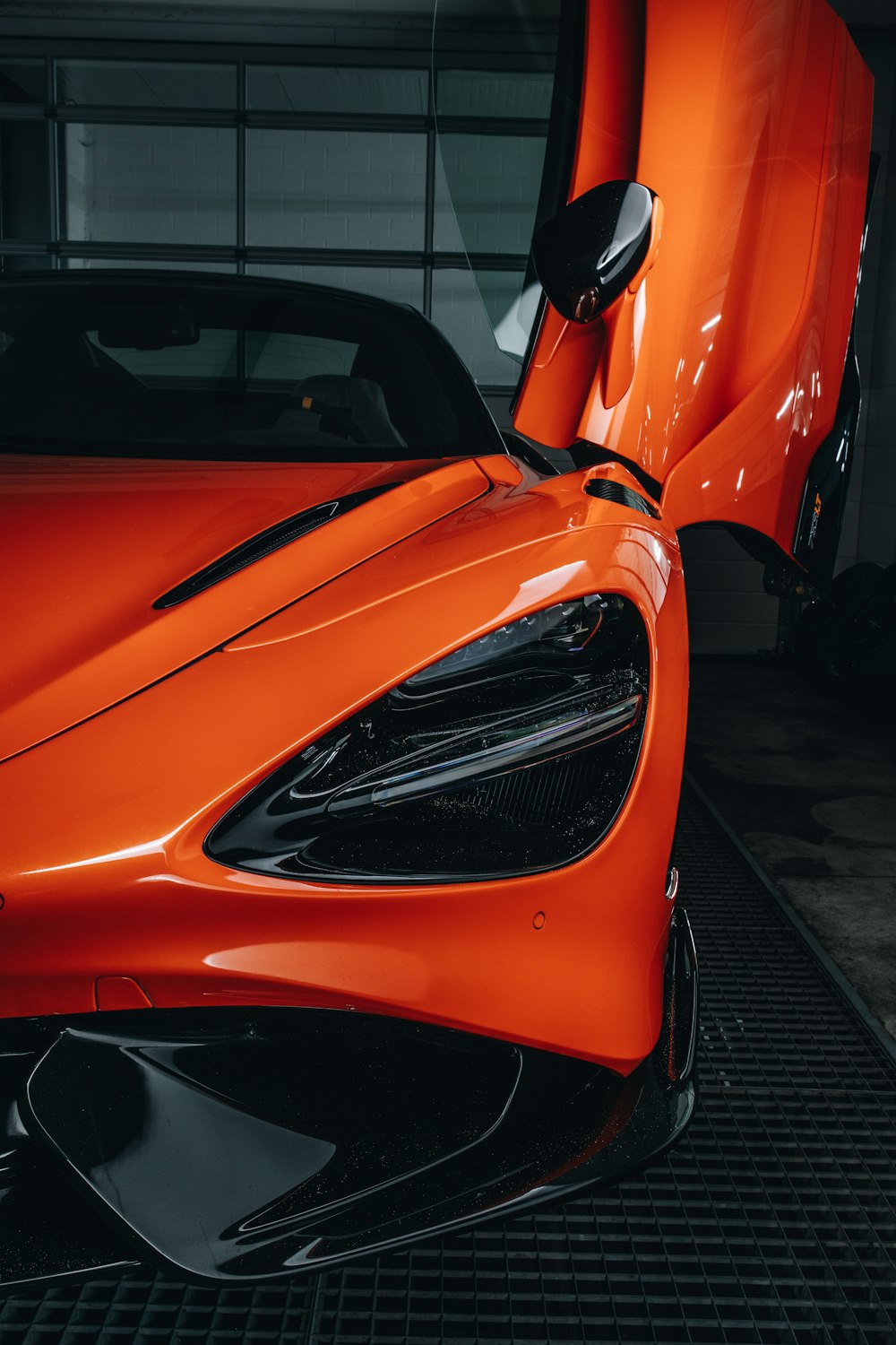 an orange motorcycle parked next to a car