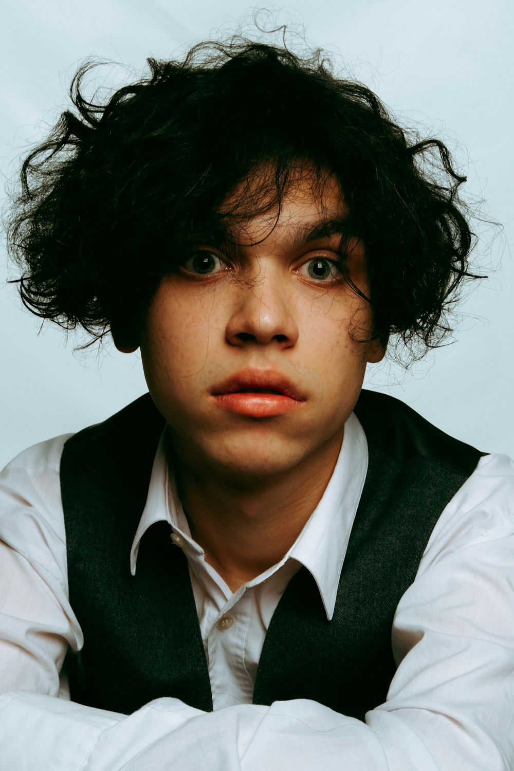 a young man with a black vest and white shirt