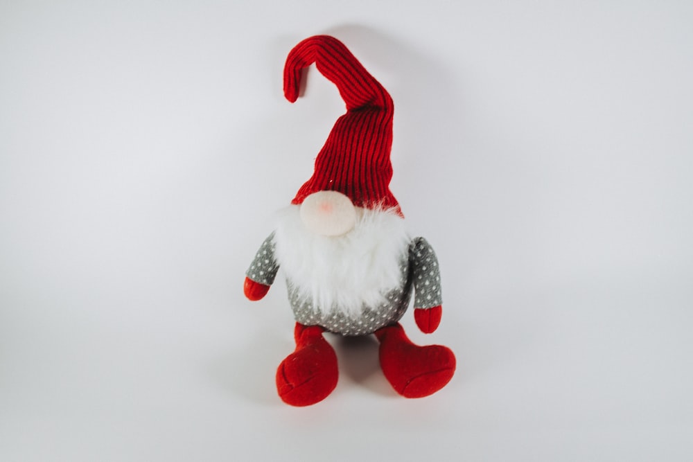 a red and white gnome doll with a red hat