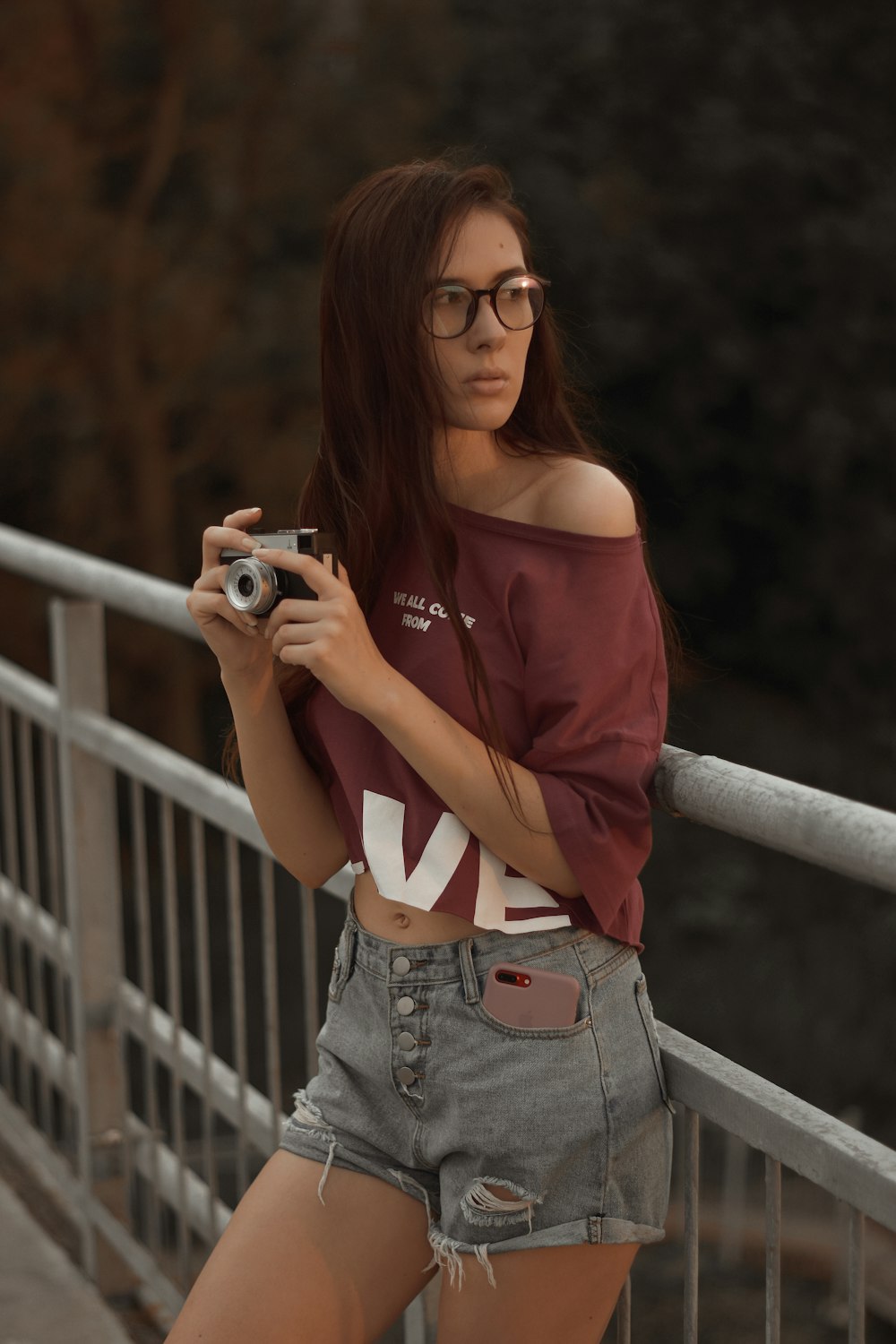 a woman with glasses is holding a camera