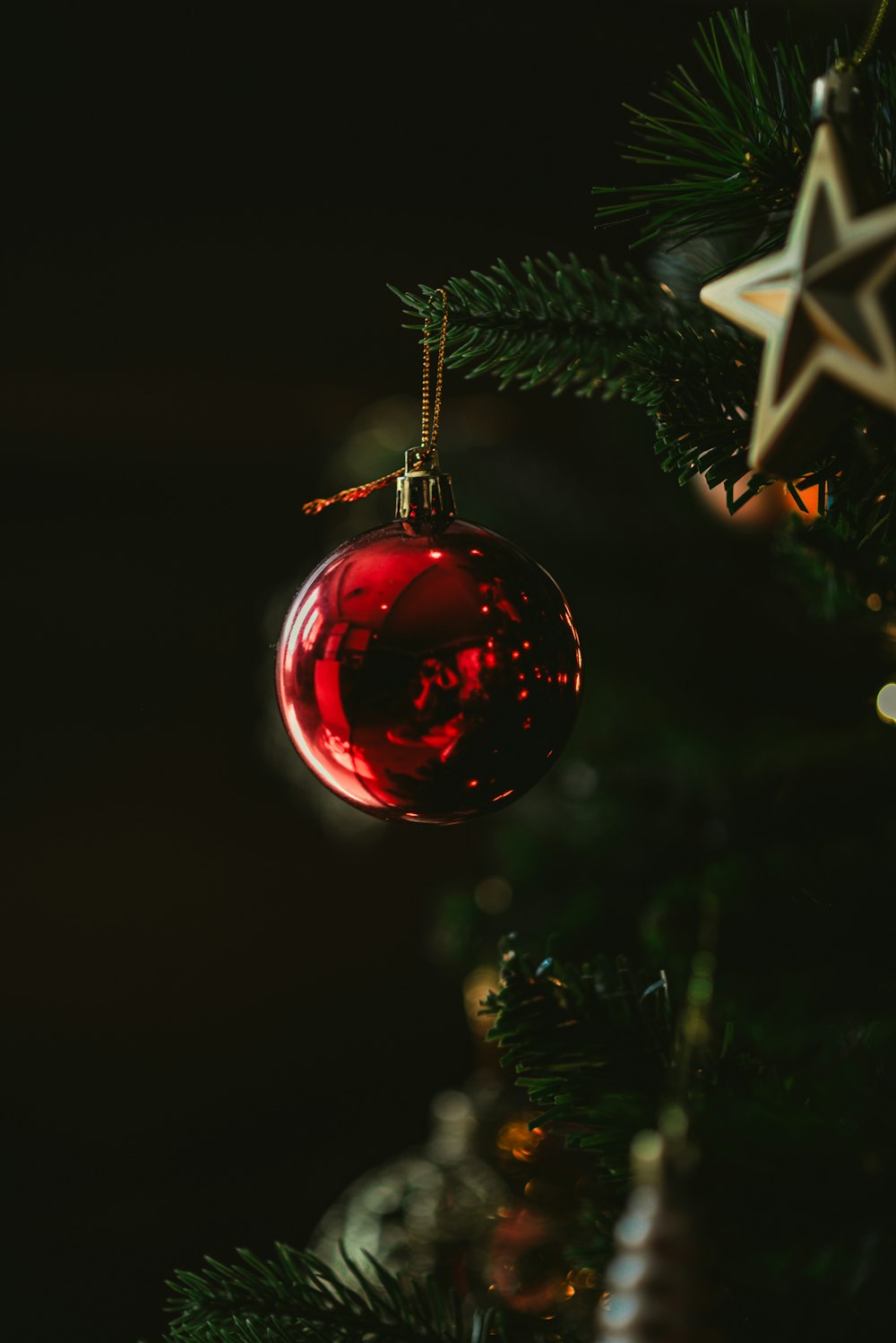 a red ornament hanging from a christmas tree