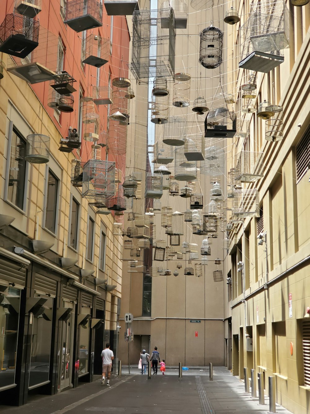 a group of people walking down a street next to tall buildings