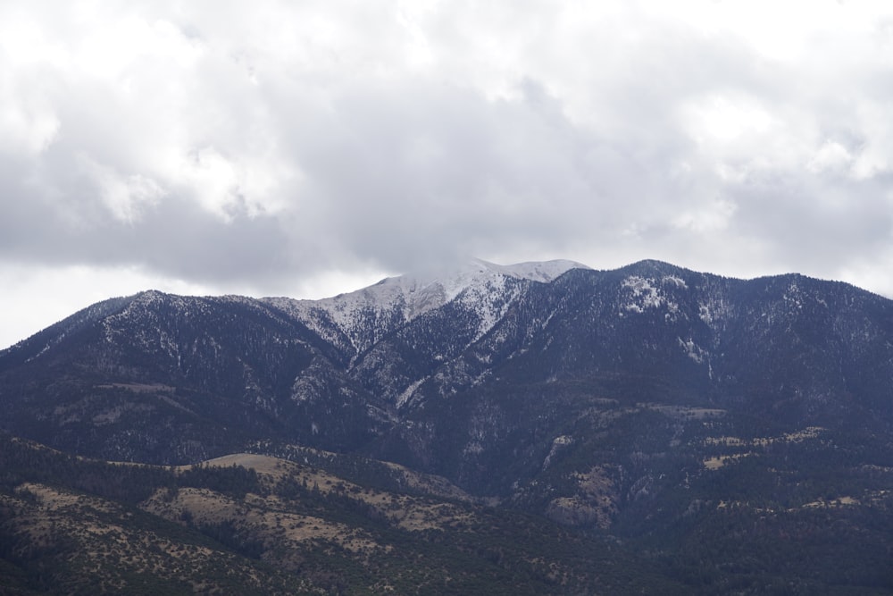 the mountains are covered in snow and clouds