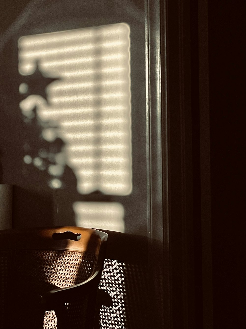 a chair sitting in front of a window next to a lamp