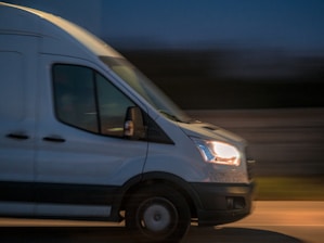 a white van driving down a street at night