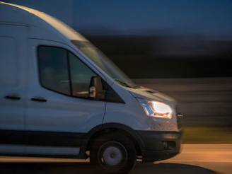 a white van driving down a street at night