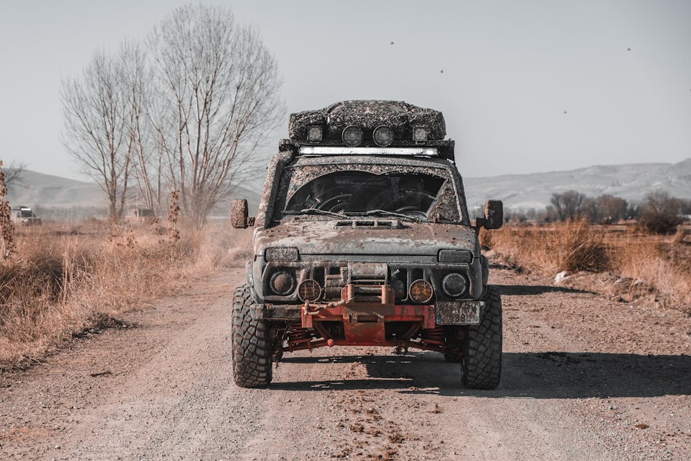 a dirty truck driving down a dirt road